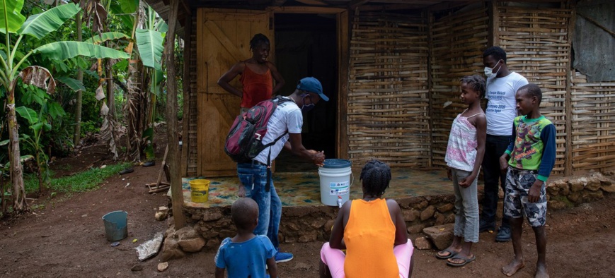 En Haïti, une équipe de l'UNICEF rend visite à une famille dans la petite ville de Dame-Marie, dans le département de Grand'Anse, pour sensibiliser à la Covid-19. © UNICEF/Haiti