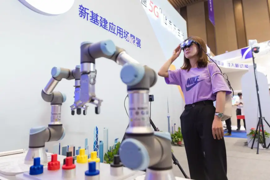A visitor experiences a 5G-driven robotic arm at an exhibition on the application scenarios of new infrastructure in Nantong city, east China’s Jiangsu province, July 30, 2020. (Photo by Zhai Huiyong/People’s Daily Online)