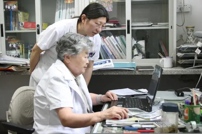 Li Huanying works with her assistant. (Photo courtesy of the Beijing Friendship Hospital affiliated to the Capital Medical University, and the Beijing Tropical Medicine Research Institute)