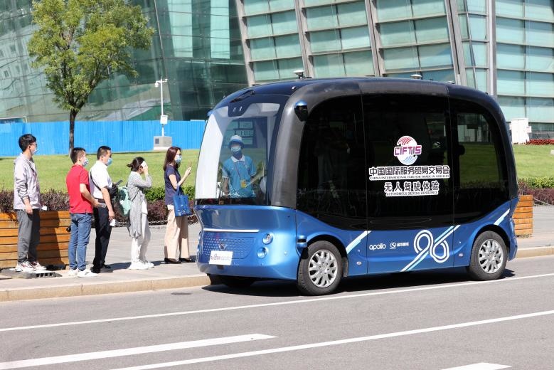 Visitors to the China International Fair for Trade in Services board an unmanned vehicle, Sept. 8, 2020. (Photo by Chen Xiaogen/People's Daily Online)