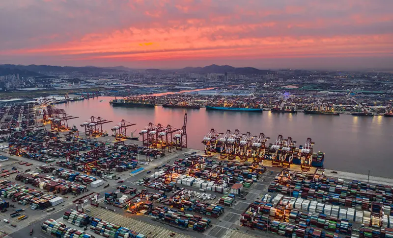 Photo shows a busy container terminal of the Qianwan area of Qingdao Port in Qingdao, east China’s Shandong province, under the sunset glow, August 27, 2021. (Photo by Wang Hua/People’s Daily Online)
