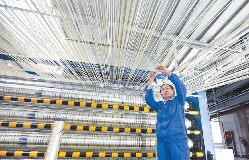 An employee of the branch of Zhongfu Shenying Carbon Fiber Co., Ltd. in Xining, capital of northwest China’s Qinghai province, connects carbon fiber precursors before they are put into carbonization furnace. (Photo by He Yingli)