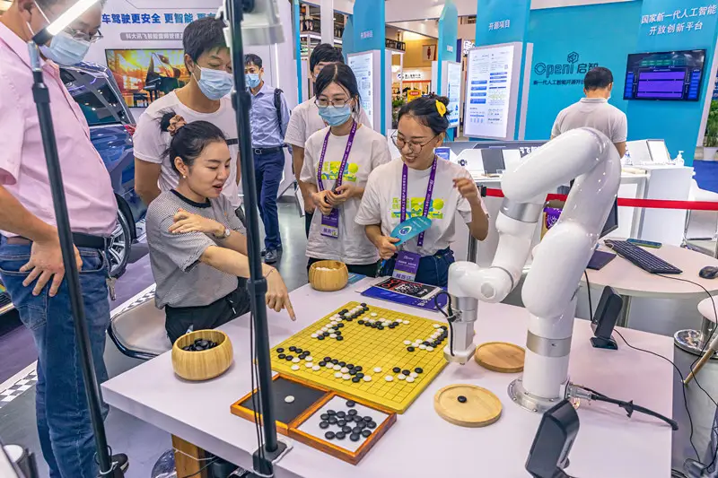 A woman plays go game with a robot at the 2021 Global AI Product & Application Expo held in Suzhou, east China's Jiangsu province, Sept. 18, 2021. (Photo by Zhang Feng/People's Daily Online)
