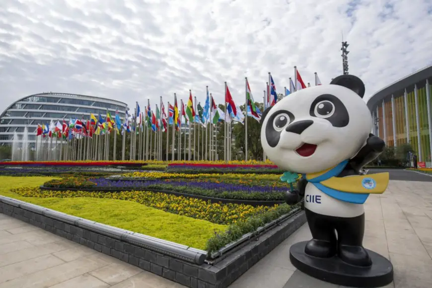 Photo taken on Nov. 4, 2021 shows blooming flowers and fluttering national flags of different countries at the south square of the National Exhibition and Convention Center (Shanghai), venue for the 4th China International Import Expo (CIIE). (Photo by Weng Qiyu/People’s Daily Online)