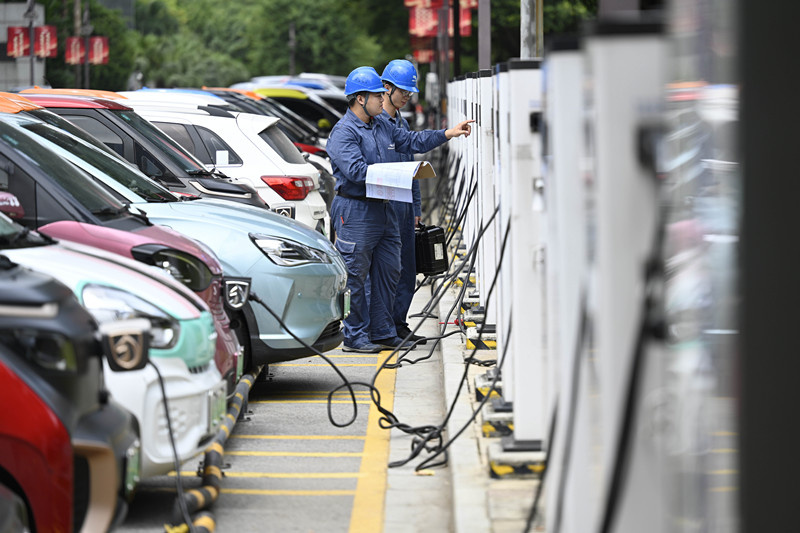 Technicians with the local power supply department check the conditions of charging poles in Liuzhou, south China's Guangxi Zhuang autonomous region, Aug. 24, 2021. (Photo by Li Hanchi/People's Daily)