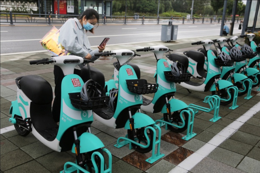 A citizen scans QR code on a shared electric scooter with her mobile phone to use the scooter. On Sept. 1, 2021, the first batch of 500 shared electric scooters were officially put into use in the urban area of Lianyungang, east China’s Jiangsu province. (Photo by Wang Chun/People’s Daily Online)