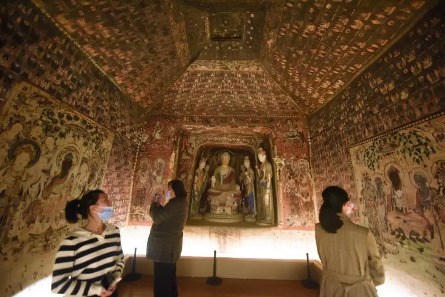 Visitors watch a 3D-printed replica of the Cave 57 of the Mogao Grottoes - a renowned site containing Buddhist art in Dunhuang, Gansu province - in the Zhejiang University Museum of Art and Archaeology in Hangzhou, Zhejiang province, Nov 2, 2021. (Photo by Long Wei/People's Daily Online)
