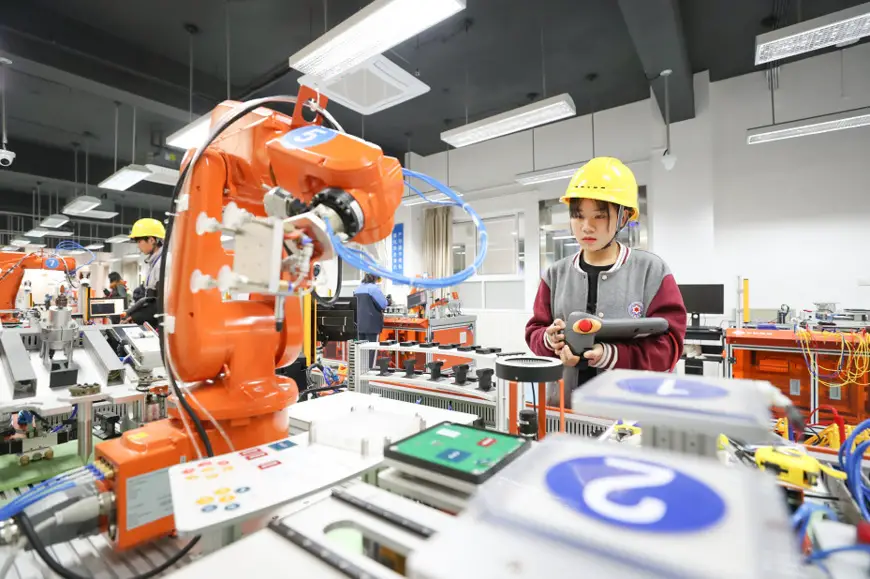 Students at Xinqiao vocational school in Songjiang district, Shanghai, operate industrial robots. The school has added a new major related to the application of industrial robot technology to its degree programs as Songjiang has made continuous efforts to advance AI and other strategic emerging industries. (Photo by Jiang Huihui/People’s Daily Online)