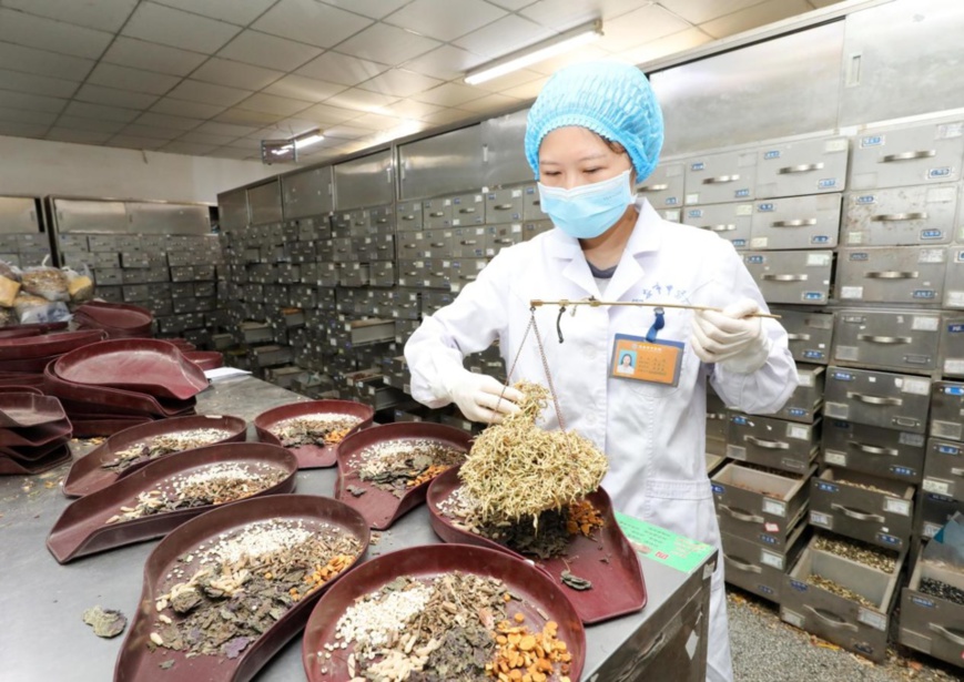 A pharmacist of traditional Chinese medicine (TCM) dispenses a prescription for epidemic prevention medicine at a TCM hospital in Huai’an city, east China’s Jiangsu province, August 19, 2021. (Photo by Wang Hao/People’s Daily Online)