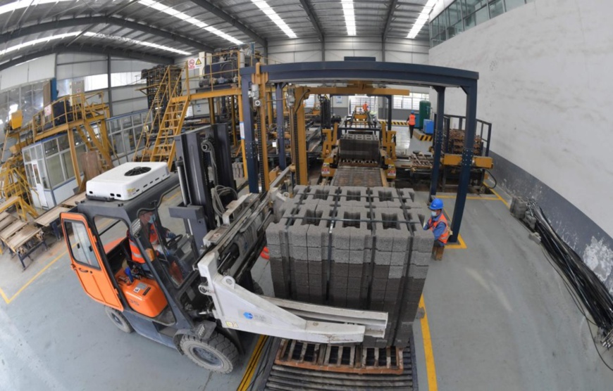 Workers load retaining wall bricks made from construction waste onto a vehicle in Xiangcheng district, Xiangyang city, central China’s Hubei province, March 24, 2020. (Photo by An Fubin/People’s Daily Online)