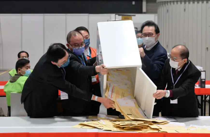 Chairman of the China's Hong Kong Special Administrative Region (HKSAR) Electoral Affairs Commission Justice Barnabas Fung Wah (2nd R) and Secretary for Constitutional and Mainland Affairs of the HKSAR government Erick Tsang Kwok-wai (2nd L) open a ballot box at a counting station in the Hong Kong Convention and Exhibition Centre, Dec. 19, 2021. (Photo from the official website of the HKSAR)