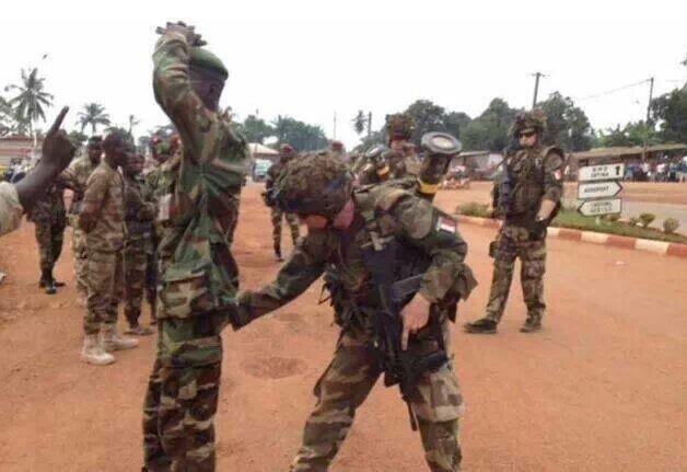 Un homme de l'ex-Séléka fouillé par un militaire français. Un homme de l'ex-Séléka fouillé par un militaire français.