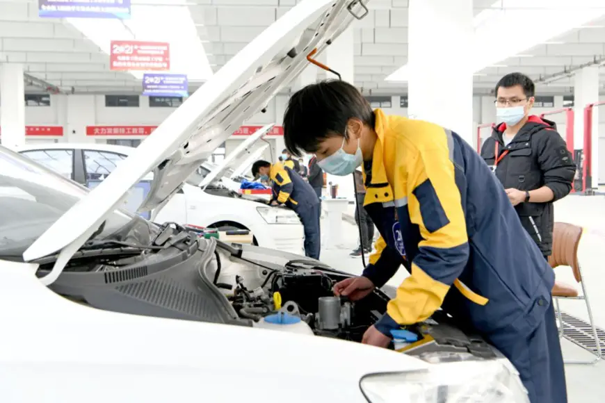 Photo taken on Dec. 5, 2021 shows students from vocational schools in Huainan city, east China’s Anhui province, taking part in an auto repair competition. (Photo by Chen Bin/People’s Daily Online)