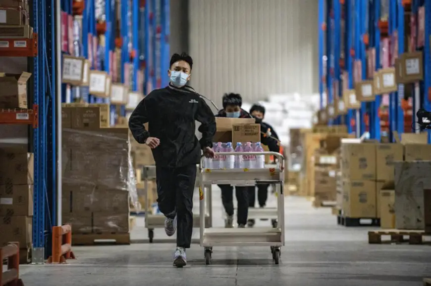 A man runs to collect parcels in a warehouse owned by Chinese e-commerce giant JD.com in Jinyi Comprehensive Bonded Zone, Jinhua, east China’s Zhejiang province, Dec. 12, 2021. (Photo by Hu Xiaofei/People’s Daily Online)