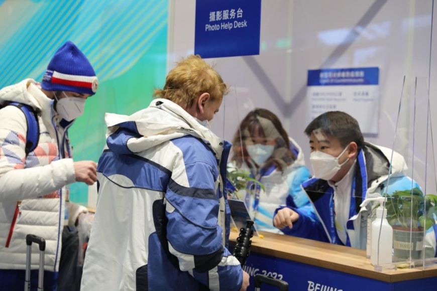 Olympic volunteers help foreign journalists at the Photo Help Desk of the Main Media Center (MMC) for the Beijing Winter Olympics, Feb. 3, 2022. (Photo by Chen Shangwen/People’s Daily Online)