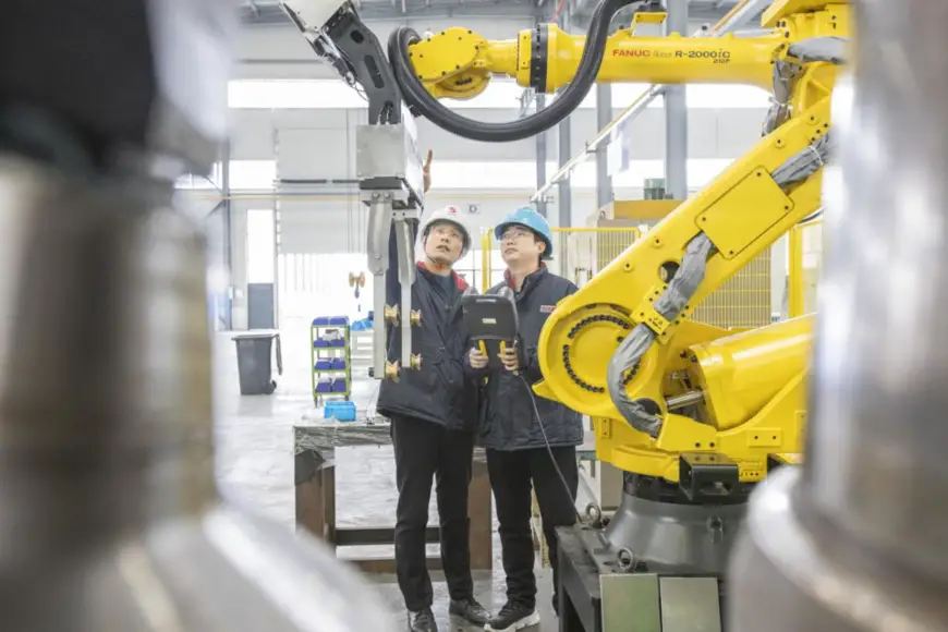 Technicians test and adjust products at an automated aluminum alloy wheel hub production line of Tianhong Intelligent Equipment Co., Ltd. based in an industrial park in Danyang Economic and Technological Development Zone, east China’s Jiangsu province, Feb. 8, 2022. (Photo by Feng Jiangjiang/People’s Daily Online)