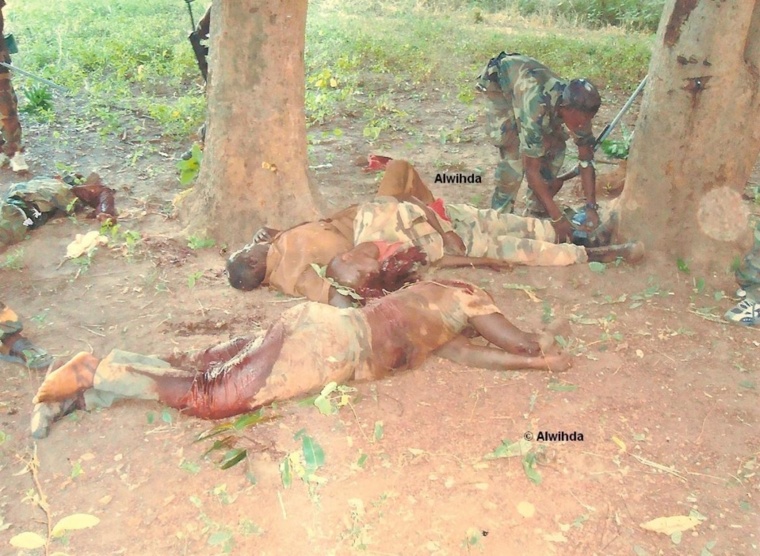 Un combattant enlève la chaussure d'un soldat des FACA tué au combat. © Alwihda Info