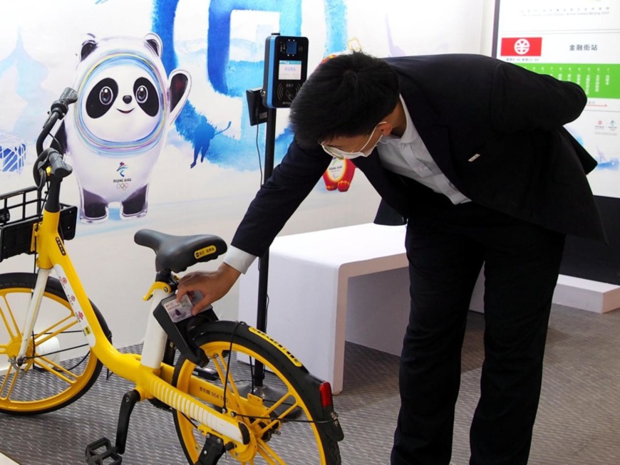 A man tries payment with digital Chinese yuan (e-CNY) on a shared bike at an exhibition of China’s digital fiat currency at the Beijing 2022 Winter Olympics, Oct. 21, 2021. (Photo by Du Jianpo/People’s Daily Online)