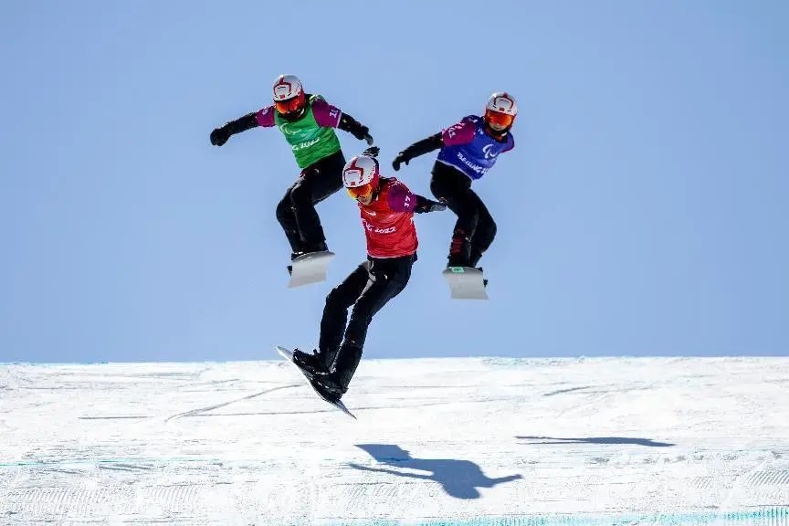 Three Chinese athletes compete in the Para snowboard men's cross SB-UL event at the Beijing 2022 Winter Paralympic Games, March 7, 2022. (Photo by Weng Qiyu/People's Daily Online)