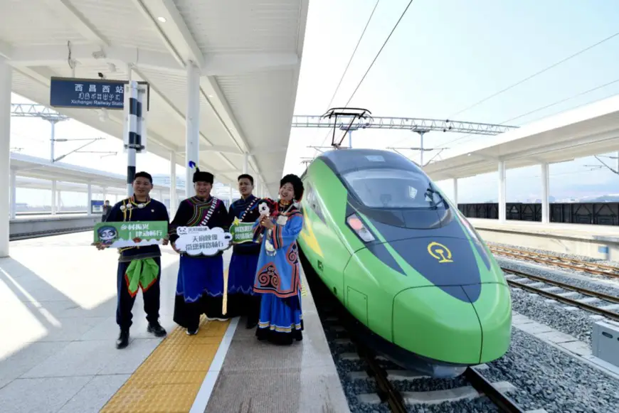 Photo taken on Jan. 10, 2022 at Xichangxi Railway Station in Liangshan Yi autonomous prefecture, southwest China’s Sichuan province, shows train attendants in traditional costumes of ethnic minority groups posing for a photo with Fuxing high-speed train No. D843, which is about to make the first trip from Xichangxi Railway Station to Kunming, capital of southwest China’s Yunnan province. The train trip marked that Liangshan Yi autonomous prefecture officially ushered in the era of high-speed trains. (Photo by Hu Zhiqiang/People’s Daily Online)