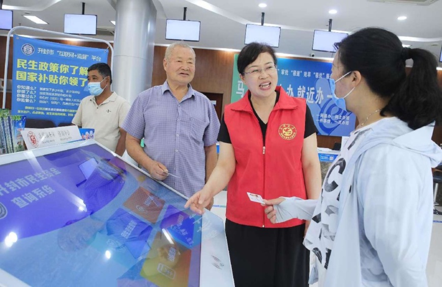 Residents of Xiaoximen village, Weishi county, Kaifeng city, central China’s Henan province, check whether their subsistence allowance has arrived in their accounts via an Internet-based supervision platform in a local government affairs service center. (Photo by Li Xinyi/People’s Daily Online)