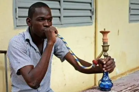 Un jeune homme fume la chicha au Tchad. Crédit photo : © ATP