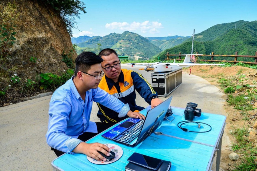 Technicians adjust the flight parameters of drones with the help of the BeiDou Navigation Satellite System (BDS) when using drones to collect video and picture data on mountains along a railway in Hanzhong city, northwest China’s Shaanxi province, in June 2020. (Photo by Yang Jinglong/People’s Daily Online)