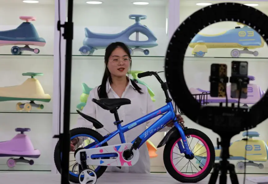 An employee with Hebei Tieniu Bicycle Industry Co., Ltd. based in Guangzong county, Xingtai city, north China’s Hebei province, sells bicycles for children via livestreaming during the 131st China Import and Export Fair, April 21, 2022. (Photo by Wang Lei/People’s Daily Online)