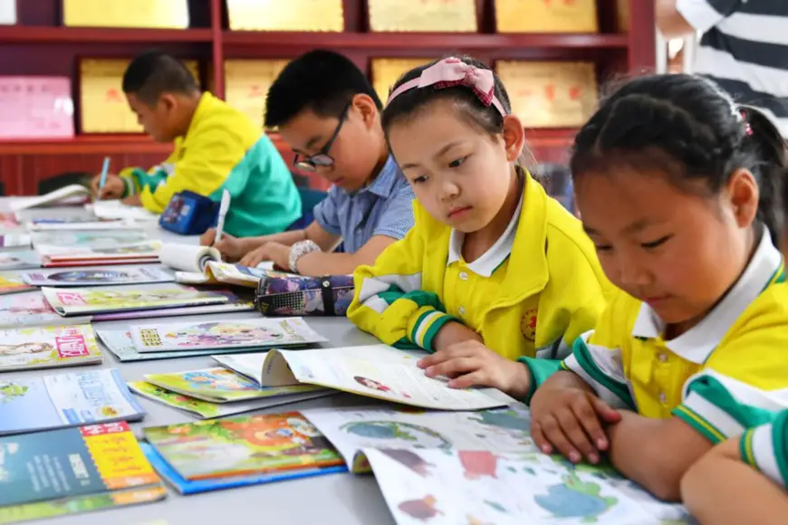 Children read books at a rural library in Shiziping village, Tianshui, Gansu province. (Photo by Zhou Wentao)