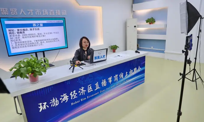 A staff member with a talent resources market in Qinhuangdao city, north China’s Hebei province, provides information about jobs for viewers during a livestreaming show, April 19, 2022. (Photo by Cao Jianxiong/People’s Daily Online)