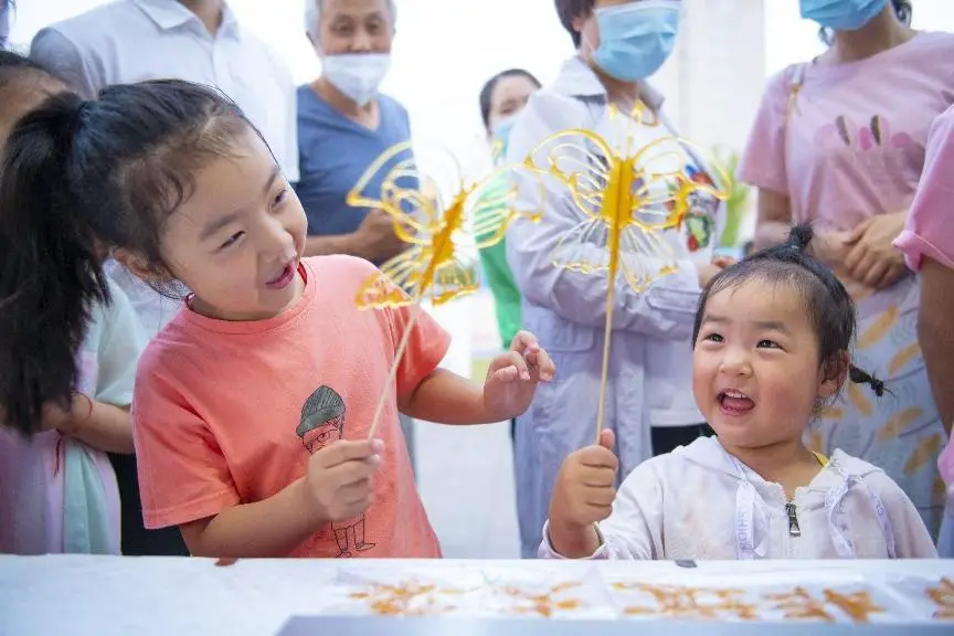 Children enjoy sugar painting, a form of traditional Chinese folk art and a snack in China, at an intangible cultural heritage-themed fair held at a square in Sucheng district, Suqian city, east China’s Jiangsu province, June 10, 2022. (Photo by Xu Jianghai/People’s Daily Online)