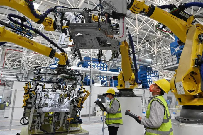 Technicians are testing equipment in an automated welding workshop at a network-linked vehicle production base in a high-tech industrial park in Shapingba district, southwest China's Chongqing municipality, Feb. 14, 2022. (Photo by Sun Kaifang/People's Daily Online)