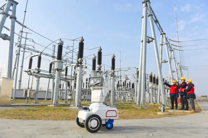 A 5G-enabled inspection robot inspects a power facility in Chuzhou, east China's Anhui province together with maintenance staff, Jan. 17, 2022. (Photo by Song Weixing/People's Daily Online)