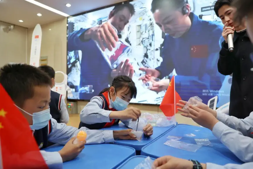 Elementary school students in Hefei, east China's Anhui province do scientific experiments while Chinese astronauts give a livestreamed popular-science lecture from China’s space station, March 23, 2022. (Photo by Chen Sanhu/People’s Daily Online)