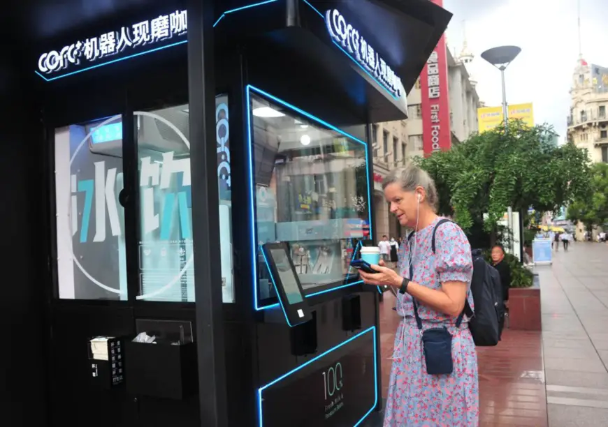 A foreign tourist orders a cup of coffee at an unattended coffee booth on the Nanjing Road Pedestrian Street in Shanghai, Aug. 12, 2021. (Photo by Yang Jianzheng/People’s Daily Online)