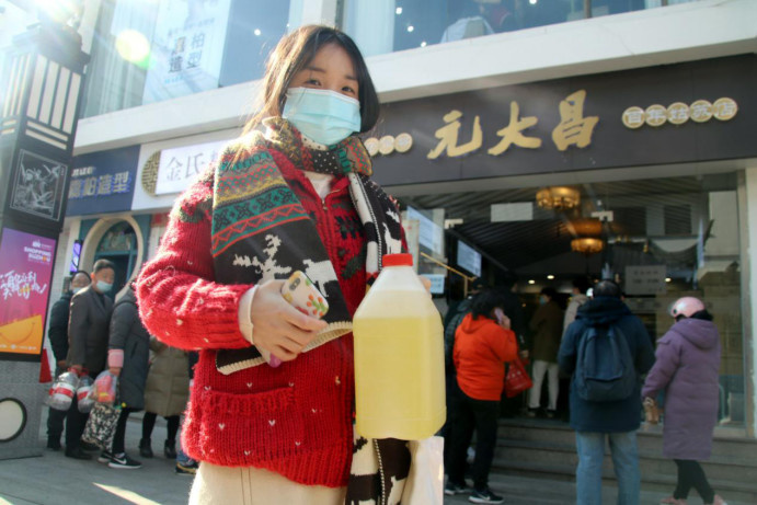 A citizen buys rice wine from a time-honored winemaker in Suzhou, east China's Jiangsu province, Dec. 19, 2020. (Photo by Wang Jiankang/People's Daily Online)