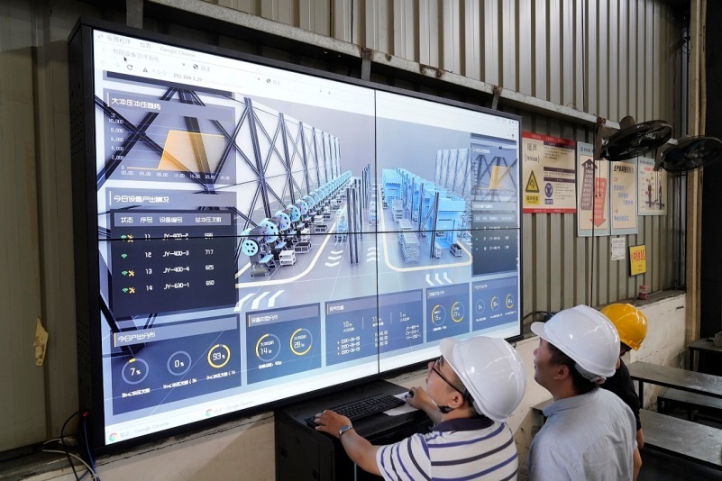 Workers of a machinery company in southwest China's Chongqing municipality check the production in a workshop on an industrial internet platform, September 2020. (Photo by Qin Tingfu/People's Daily Online)