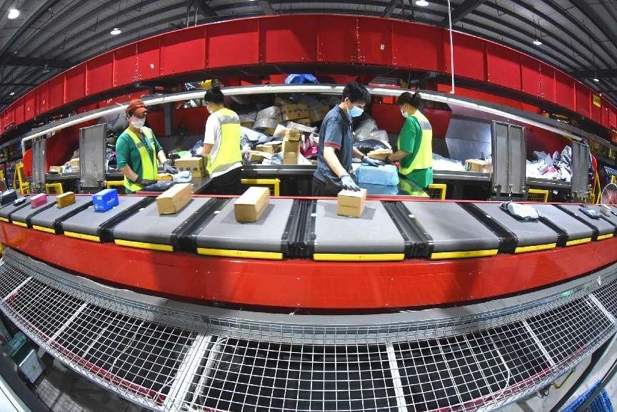 Workers are sorting express delivery parcels in a warehouse of a major express delivery company in an industrial park in Lianyungang, east China's Jiangsu province, June 14, 2022. (Photo by Geng Yuhe/People's Daily Online)