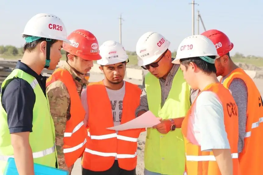 Photo shows Chinese and Uzbek engineers at the construction site of a road project in Uzbekistan contracted by China Railway Construction Corporation. (Photo provided by China Railway 20 Bureau Group Corporation)