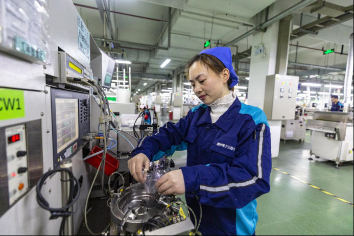 A worker produces electronic parts and components in a workshop of a company in Sihong county, east China's Jiangsu province, Dec. 5, 2020. The company, a supplier for renowned IT firms such as Huawei, Foxconn and Samsung, holds 34 unity model and invention patents. (Photo by Chen Yu/People's Daily Online)