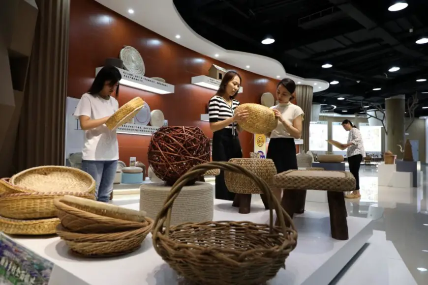 People buy grass weaving products at a grass and wicker weaving-themed industrial park in Boxing county, Binzhou, east China's Shandong province, Aug. 9, 2022. (Photo by Chen Bin/People's Daily Online)