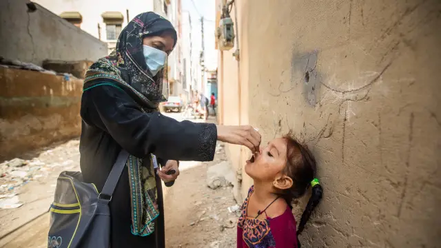 Samreen (3 ans), est vaccinée par Samina (27 ans), vaccinatrice contre la polio, à Qayyumabad, Korangi, Karachi, Pakistan, le 23 septembre 2020. ©Gates Archive/Khaula Jamil