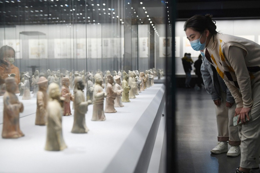 A woman watches cultural relics displayed at an exhibition of Ming Dynasty (1368-1644) treasures held at Fuyang, east China's Anhui province, November, 2022. (Photo by Wang Biao/People's Daily Online)