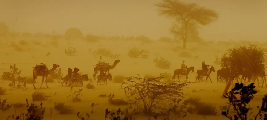 Des hommes traversent une tempête de sable à dos de chameaux et d'ânes près de la ville de Mao, dans la région de Kanem au Tchad. © UNICEF/UNI82205/Holt