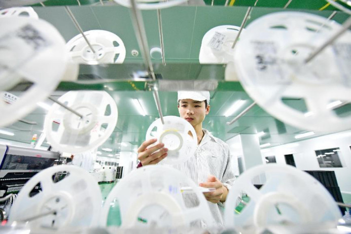 A man manufacturers 5G products at a digital workshop of a tech firm in Ganzhou, east China's Jiangxi province, May 31, 2022. (Photo by Zhu Haipeng/People's Daily Online)