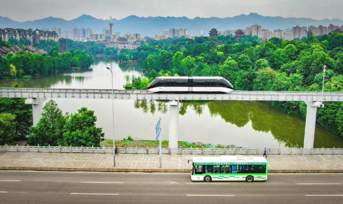 A car of an elevated rubber-tyred metro line and a new energy vehicle run in Bishan district, southwest China's Chongqing municipality. (Photo by Hu Yuejian/People's Daily Online)