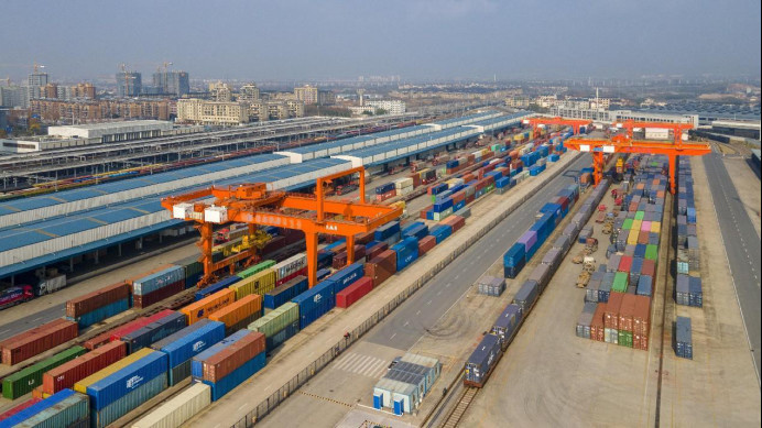 Aerial photo taken on Jan. 6, 2023 shows containers being loaded into a China-Europe freight train at a platform of the Yiwu-Xinjiang-Europe cargo line in Jinhua city, east China's Zhejiang province. (Photo by Hu Xiaofei/People's Daily Online)