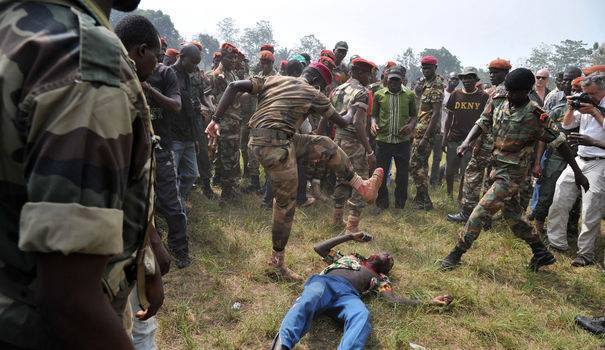 Un jeune homme en civil lynché par des soldats des Forces armées centrafricaines (FACA), réunis lors d'une cérémonie marquant leur reformation, en présence de la nouvelle présidente Catherine Samba Panza. Un jeune homme en civil lynché par des soldats des Forces armées centrafricaines (FACA), réunis lors d'une cérémonie marquant leur reformation, en présence de la nouvelle présidente Catherine Samba Panza.