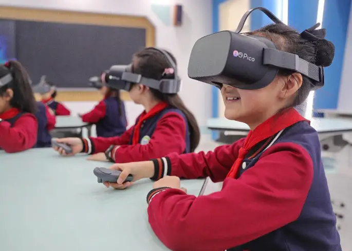 Students have a science class wearing virtual reality headsets in a primary school in Qinhuangdao, north China's Hebei province. (Photo by Cao Jianxiong/People's Daily Online)