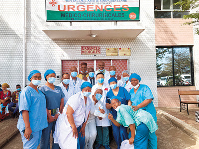 Guo Wei, chief physician of the emergency department of Beijing Tiantan Hospital and head of the 29th Chinese medical aid team to Guinea poses for a picture with Guinean medical workers.